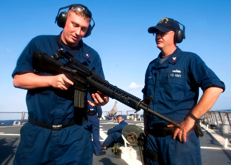 US Navy 111026-N-FI736-049 Fire Controlman 1st Class Jason Parkhill teaches Operations Specialist Second Class Carl Young the weapon conditions of