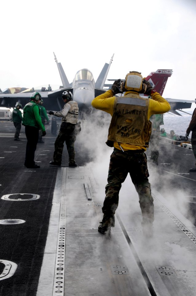 US Navy 111025-N-VD490-015 Aviation Boatswain's Mate (Handling) Airman Reid Osborne, from Chesapeake, Va., signals the pilot of an F-A-18E Super Ho
