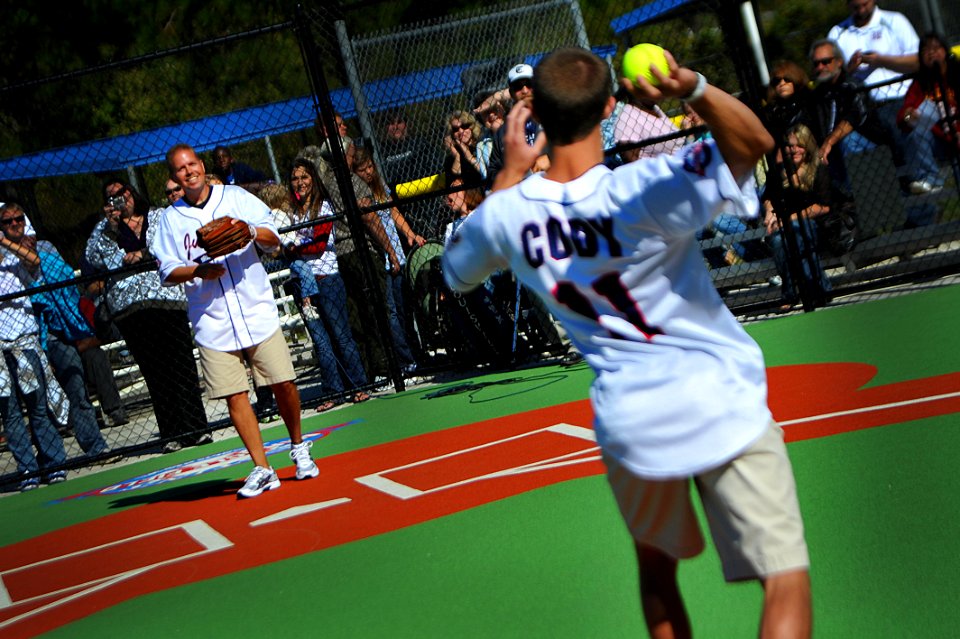 US Navy 111022-N-YR391-054 Senior Chief Missile Technician Jeff Norris catches the first pitch from his son at the Miracle Field grand opening in C
