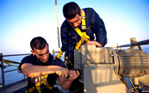 US Navy 111025-N-GC412-250 nterior Communications Electrician Firemen Jonathan Alomar, left, and Thomas Trevillyan replace a panel on the ship's ho