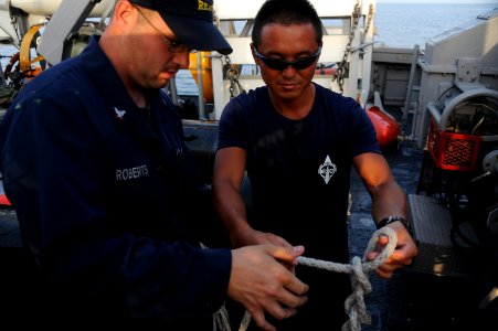 US Navy 111026-N-RP435-049 An explosive ordnance disposal diver shows Mineman 3rd Class James Roberts how to tie a quick release knot