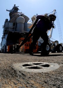 US Navy 111025-N-WJ771-391 Aviation Boatswain's Mate (Fuel) 1st Class Joseph C. Determan carries a fuel hose across the flight deck of the forward