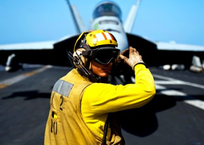US Navy 111026-N-BT887-045 Aviation Boatswain's Mate (Handling) 2nd Class Jose Rodriguez directs an F-A-18E Super Hornet from the Tophatters of Str