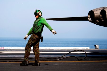 US Navy 111026-N-BT887-229 Aviation Boatswain's Mate (Equipment) 3rd Class Brock Puffett signals to retract an arresting gear cable aboard the Nimi