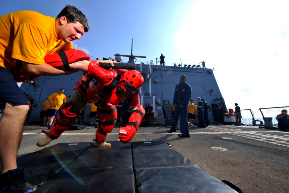 US Navy 111023-N-YZ751-090 Operations Specialist Seaman Stewart A. Dorsey takes down a target with a baton after being sprayed in the eyes with ole