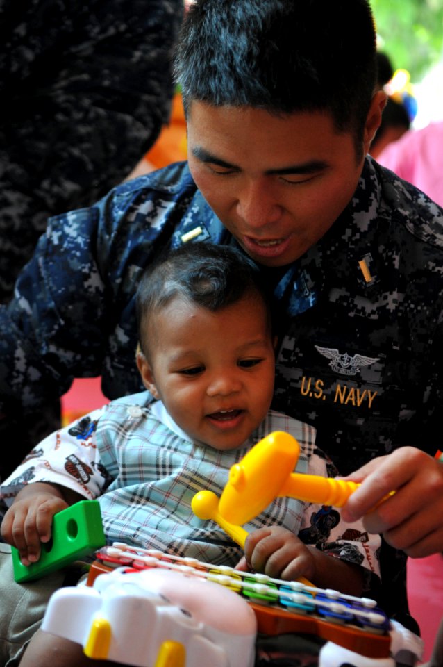US Navy 111025-N-WW409-129 Ensign James Kim, assigned to the guided-missile destroyer USS Mustin (DDG 89), plays with a child at the Pattaya Orphan