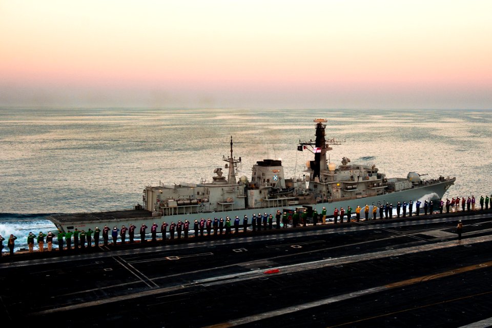US Navy 111024-N-BT887-925 Sailors render honors as the Royal Navy Duke-class frigate HMS St. Albans (F 83) pulls alongside the Nimitz-class aircra
