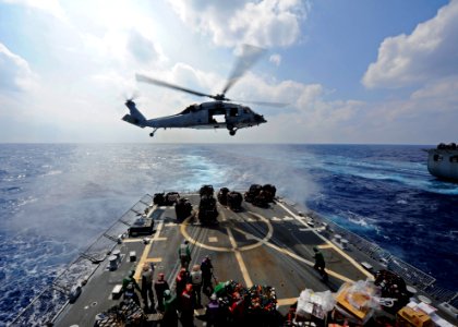 US Navy 111025-N-VH839-048 An MH-60R Sea Hawk helicopter transfers supplies to the flight deck of the Arleigh Burke-class guided-missile destroyer photo