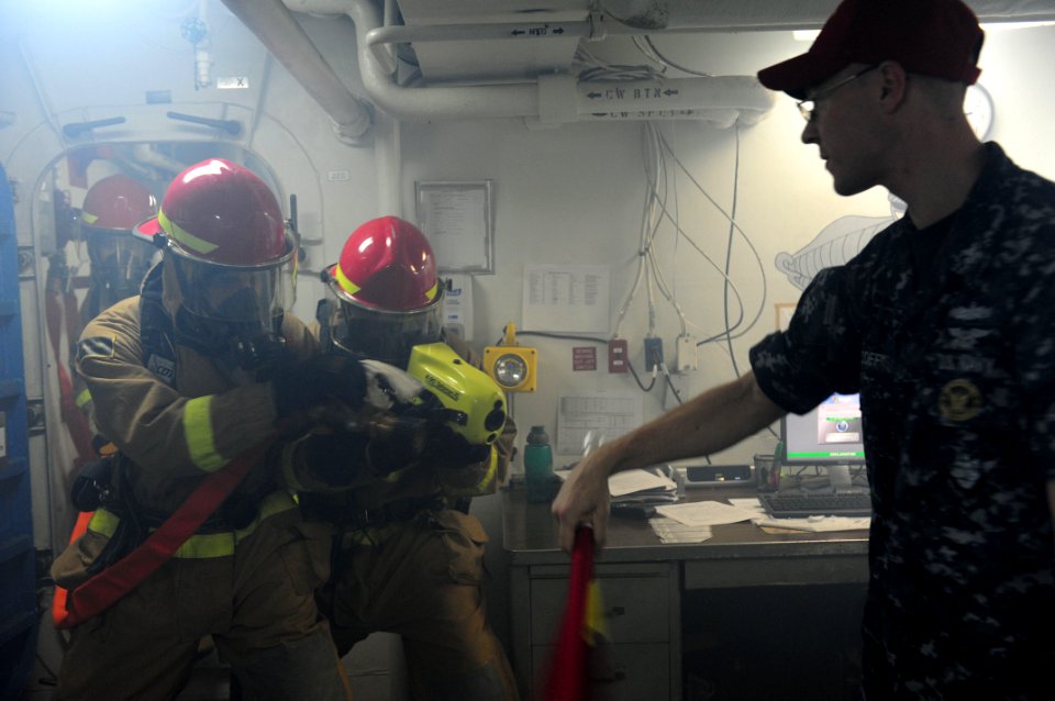 US Navy 111026-N-WA347-085 Sailors enter a smoke filled compartment during a damage control drill aboard the forward deployed amphibious assault sh