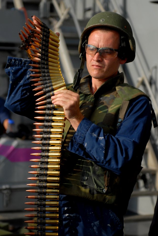 US Navy 111028-N-DU438-138 Quartermaster Seaman Christopher Taylor prepares to load ammunition into an M240 machine gun during a gunnery exercise a