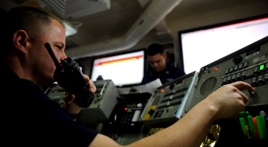 US Navy 111026-N-OY799-028 Aviation Ordnanceman 1st Class John Clark, from Grapevine, Texas, performs a comms checks from ordnance control room abo