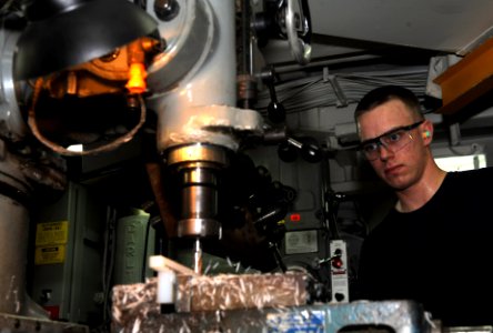 US Navy 111025-N-OY799-174 Machinery Repairman Fireman Dane McDonald, from Milwaukee, Wis., fabricates a tool on a universal milling machine photo