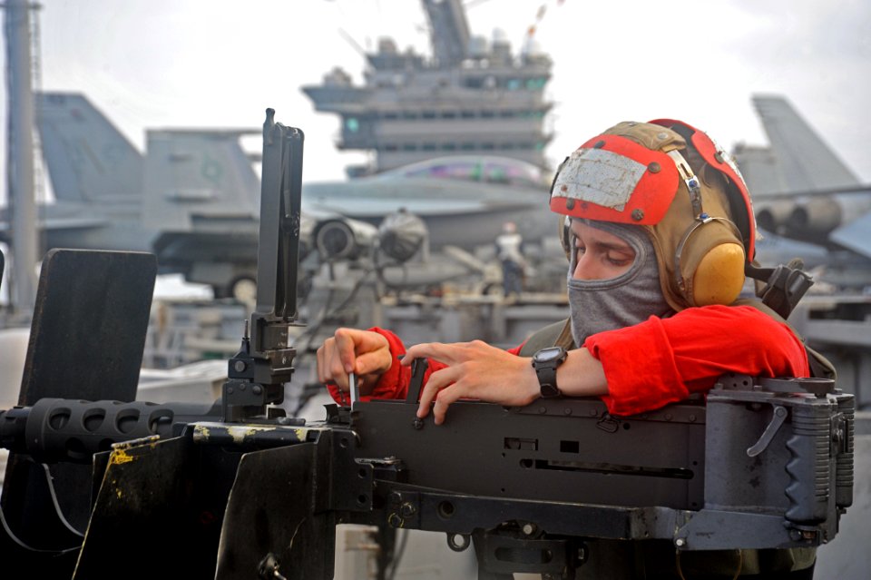 US Navy 111026-N-SF704-081 Airman Andrew Allport, from Detroit, installs the firing pin into a .50-caliber machine gun while preparing for a live-f