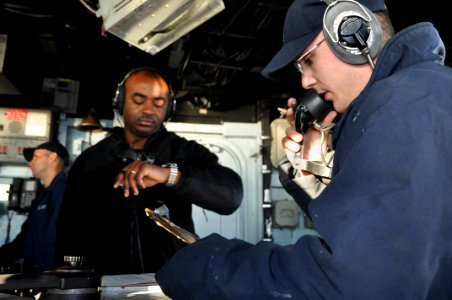 US Navy 111025-N-YX169-387 Operations Specialist Seaman Recruit Patrick Lloyd, right, uses a sound-powered phone to make a report from the bridge o
