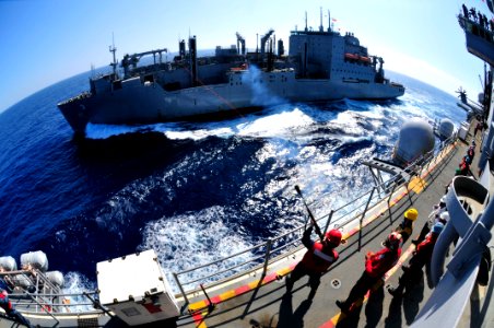 US Navy 111027-N-KM175-019 Gunner's Mate 2nd Class Davis Harris, left, fires a shot line to the Military Sealift Command dry cargo and ammunition s