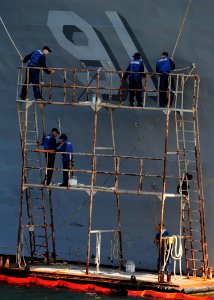 US Navy 111028-N-ED900-073 Sailors assigned to the Arleigh Burke-class guided-missile destroyer USS Pinckney (DDG 91) prepare to paint the bow of t