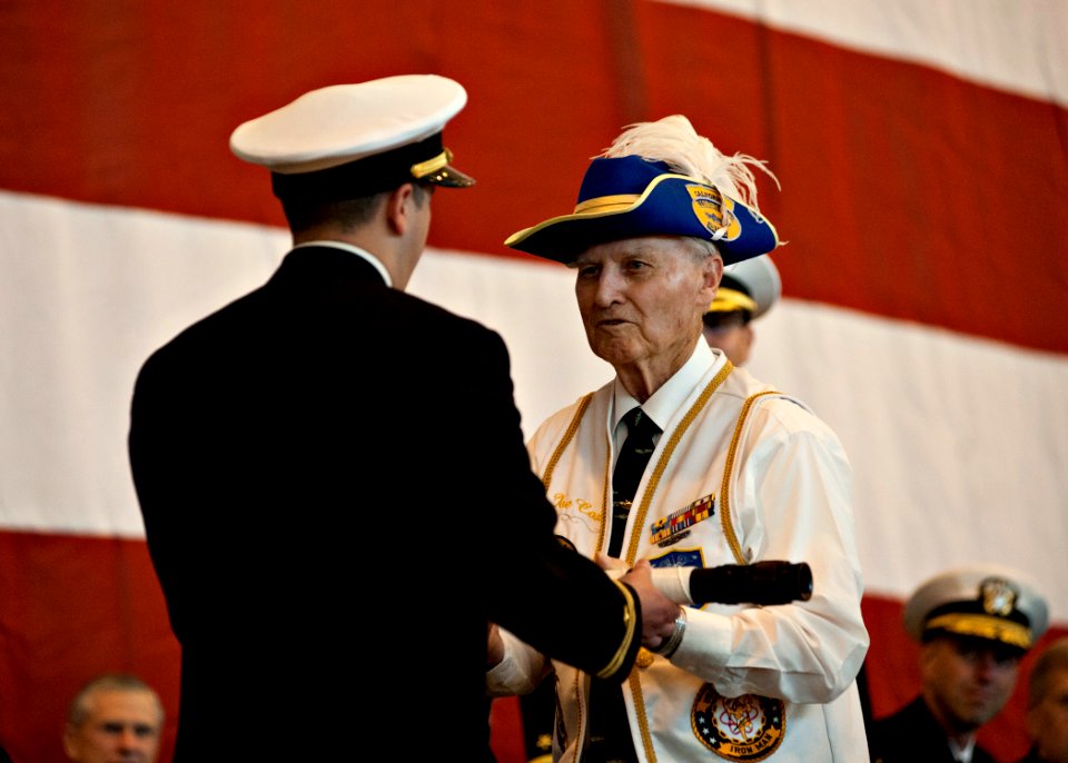 US Navy 111029-N-NY820-138 World War II submarine veteran Joe Cox passes the long glass to set the first watch during the commissioning ceremony f