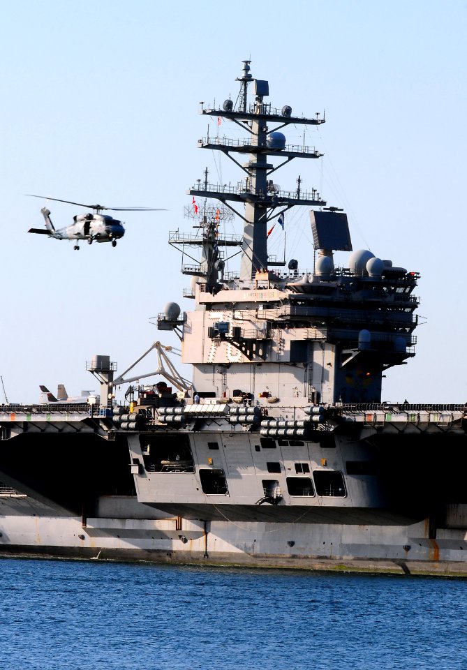 US Navy 111103-N-KB563-161 An SH-60S Sea Hawk helicopter flies above the aircraft carrier USS Ronald Reagan (CVN 76) as it returns to homeport