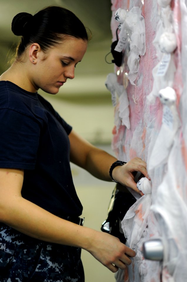 US Navy 111030-N-XE109-457 Aviation Electronics Technician Airman Stephanie L. Tschida hangs Halloween decorations aboard the aircraft carrier USS