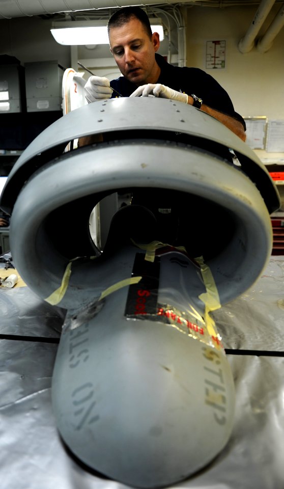 US Navy 111102-N-OY799-030 Aviation Support Equipment Technician 2nd Class Jason Thompson, from Ontario, Calif., repairs fiberglass on helicopter i