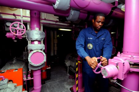 US Navy 111103-N-JD217-029 Aviation Boatswain's Mate (Fuel) Airman Benjamin C. Slater secures a valve in a fuel pump room aboard the aircraft carri