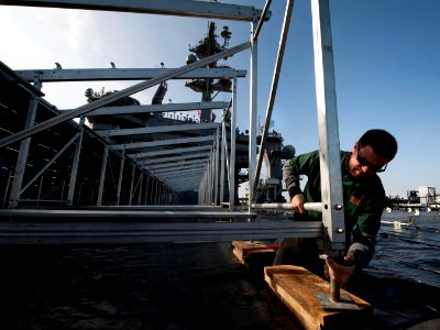 US Navy 111103-N-DR144-163 SGA Productions stage technician Joshua Mayer secures the footing on bleachers as workers build a basketball arena on th