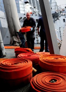 US Navy 111104-N-ED900-083 Damage Controlman 2nd Class Anthony Barrera, moves a fire hose after performing a static pressure test aboard to the Arl