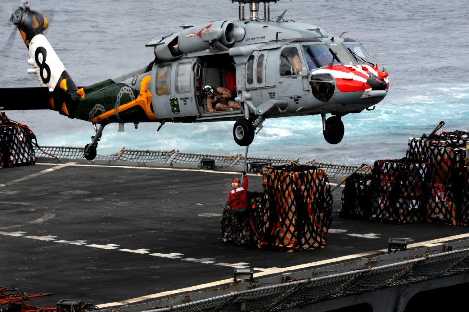 US Navy 111103-N-OY799-382 A Sailor from fast combat support ship USNS Rainier (T-AOE 7) hooks cargo to an MH-60S Sea Hawk helicopter during a repl