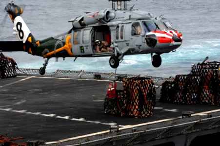 US Navy 111103-N-OY799-382 A Sailor from fast combat support ship USNS Rainier (T-AOE 7) hooks cargo to an MH-60S Sea Hawk helicopter during a repl