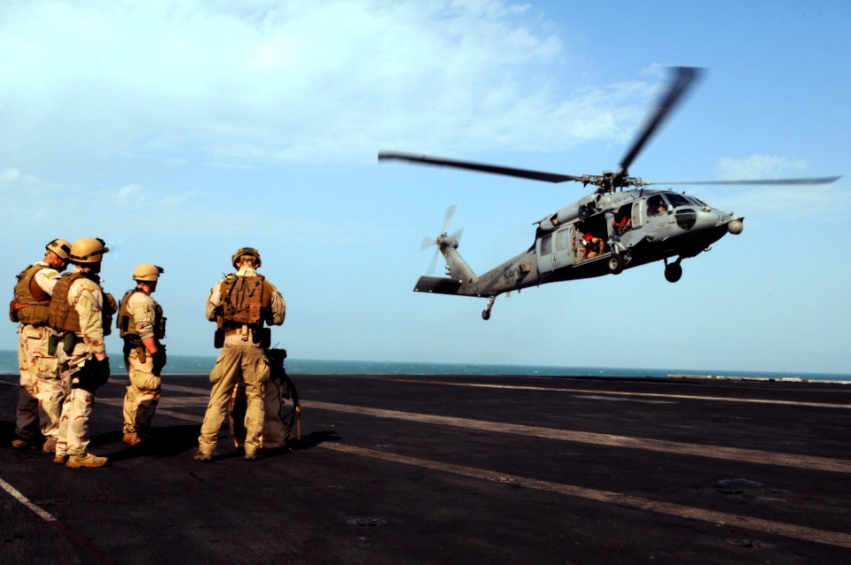 US Navy 111101-N-JD217-233 Sailors assigned to Explosive Ordnance Disposal Mobile Unit 2 board an MH-60S Sea Hawk helicopter during a fast-rope exe