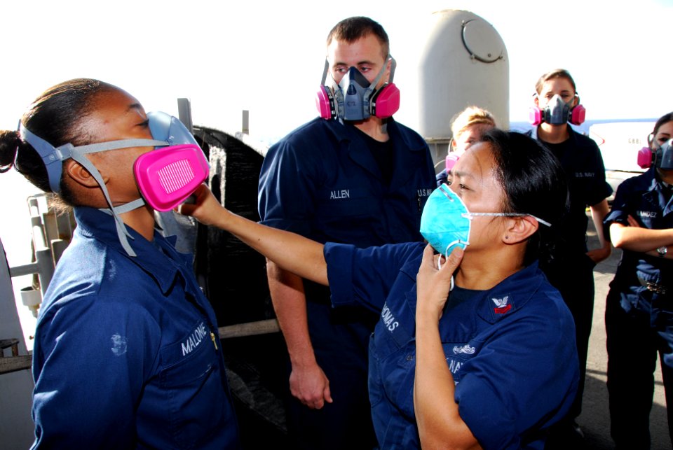 US Navy 111101-N-KF029-025 Damage Controlman 1st Class Rebecca Thomas, from San Antonio, uses irritant smoke to test the seal of a respirator durin