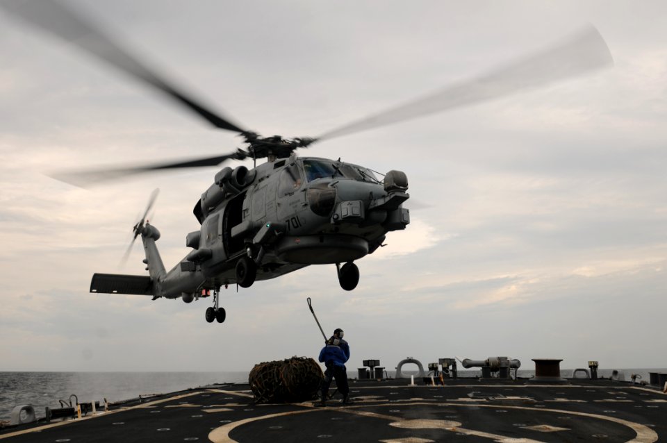 US Navy 111101-N-XQ375-504 Sailors attach a cargo net to an MH-60R Sea Hawk helicopter