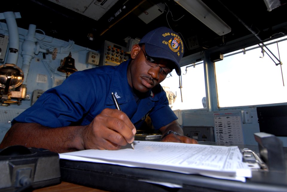US Navy 111105-N-DU438-039 Quartermaster 3rd Class Brandon Shannon writes an entry into the ship's deck log during a quartermaster watch