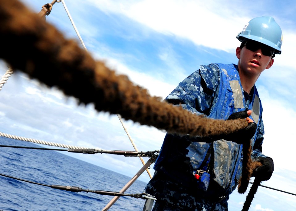 US Navy 111106-N-ED900-273 Gunner's Mate 3rd Class Maxwell Link takes the slack from a line pulling a fueling probe during a replenishment at sea a