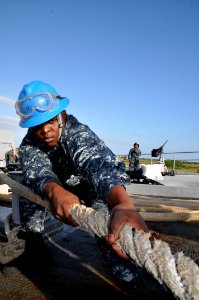 US Navy 111101-N-YX169-161 Seaman Apprentice Christopher Newell heaves around a mooring line on the forcastle of the amphibious transport dock ship