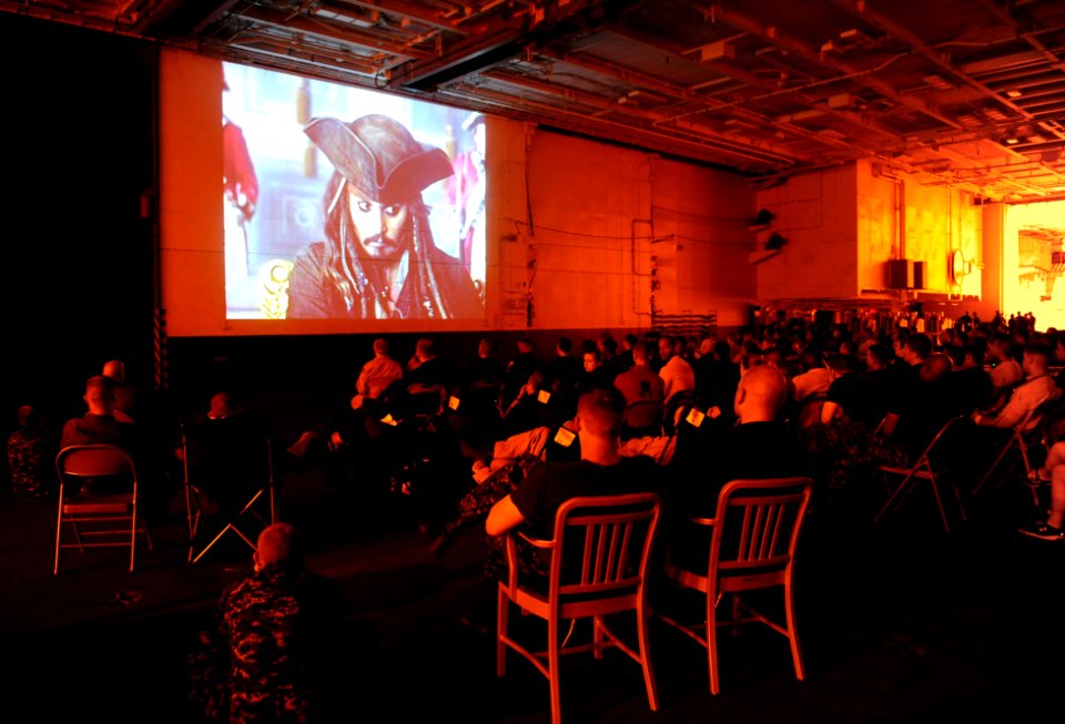 US Navy 111102-N-QL471-757 Sailors watch a movie during movie night in the hangar bay aboard the aircraft carrier USS George H.W. Bush