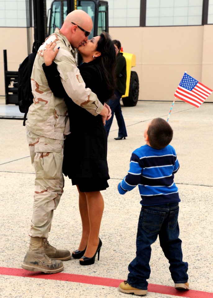 US Navy 111104-N-FJ200-060 Sailor receives a kiss from his wife during a homecoming celebration