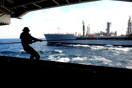 US Navy 111108-N-QL471-026 Seaman Matthew D. Trevino heaves a line aboard the aircraft carrier USS George H.W. Bush (CVN 77) after a replenishment photo