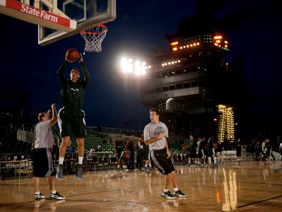 US Navy 111110-N-DR144-737 Michigan State University basketball player Alex Gauna dunks during a practice in the basketball arena on the flight dec