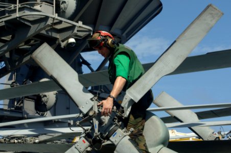 US Navy 111106-N-DS193-155 Sailor conducts a flight inspection on the tail rotor