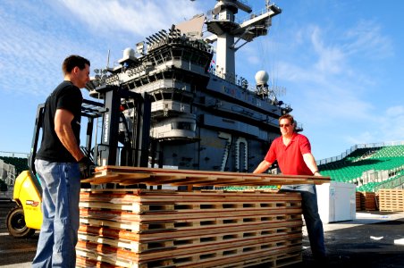 US Navy 111108-N-SB672-041 McWil Sport Surfaces employees begin laying the hardwood floor for a basketball court aboard the Nimitz-class aircraft c photo