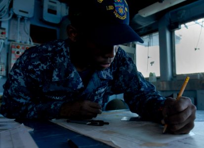 US Navy 111110-N-KA046-055 Quartermaster Seaman Dorne Adams, from Shreveport, La., plots fixes on a chart aboard the amphibious dock landing ship