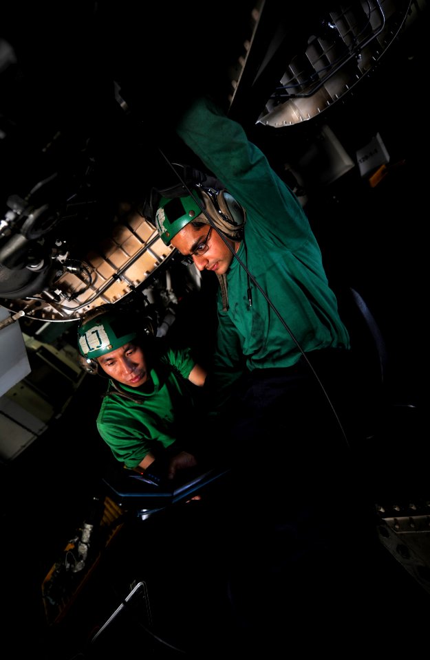 US Navy 111108-N-OY799-093 Aviation Machinist's Mate Airman Wingcheon Lam and Aviation Machinist's Mate 2nd Class Shresht Joshi repair an F-A-18F S