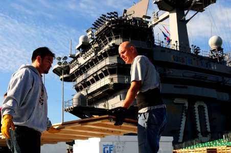 US Navy 111108-N-SB672-019 McWil Sport Surfaces employees begin laying the hardwood floor for a basketball court aboard the Nimitz-class aircraft c photo