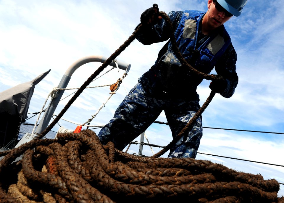 US Navy 111106-N-ED900-179 Gunner's Mate 3rd Class Maxwell Link, takes in slack from a line pulling a fueling probe during a replenishment at sea