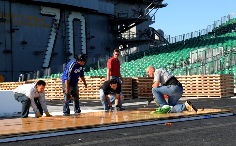 US Navy 111108-N-RG587-131 McWil Sport Surfaces employees begin laying the hardwood floor for a basketball court aboard the Nimitz-class aircraft c