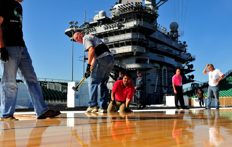 US Navy 111108-N-ZI635-102 McWil Sport Surfaces employees begin laying hardwood flooring for a basketball court aboard the Nimitz-class aircraft ca