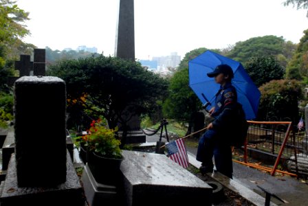 US Navy 111111-N-MU720-011 A scout from Cub Scouts Pack 33 Yokosuka, prepares to place an American flag on the grave of a fallen service member at