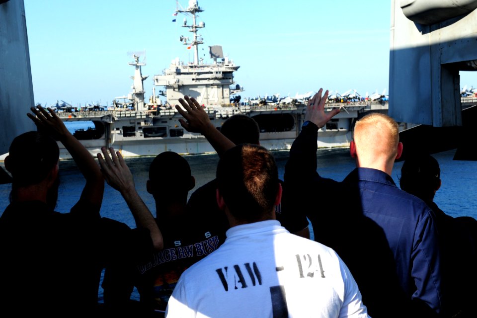 US Navy 111112-N-QL471-514 Sailors wave as the ships part from a vertical replenishment