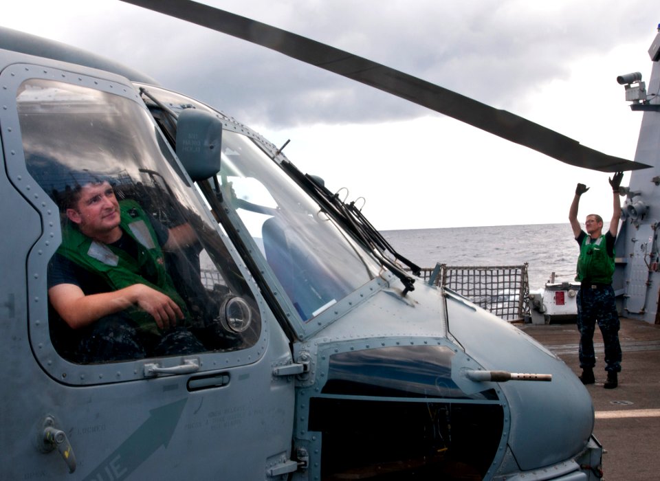 US Navy 111110-N-WX059-057 Aviation Electricians Mate Airman Alec Fisher, right, inspects an SH-60B Sea Hawk helicopter during flight operations ab